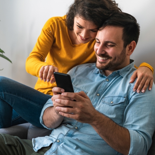 Spēlētāji piedalās online spēlē Apslēptās zināšanas, mājās uz dīvāna kopā atbildot uz jautājumiem telefonā